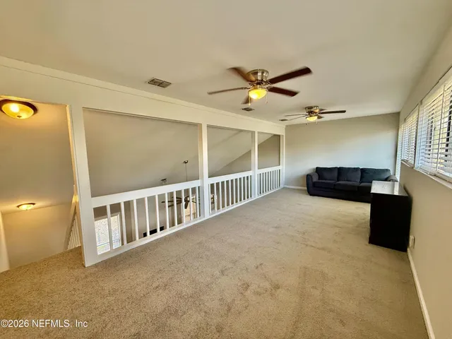 a view of a hallway with windows and chandelier