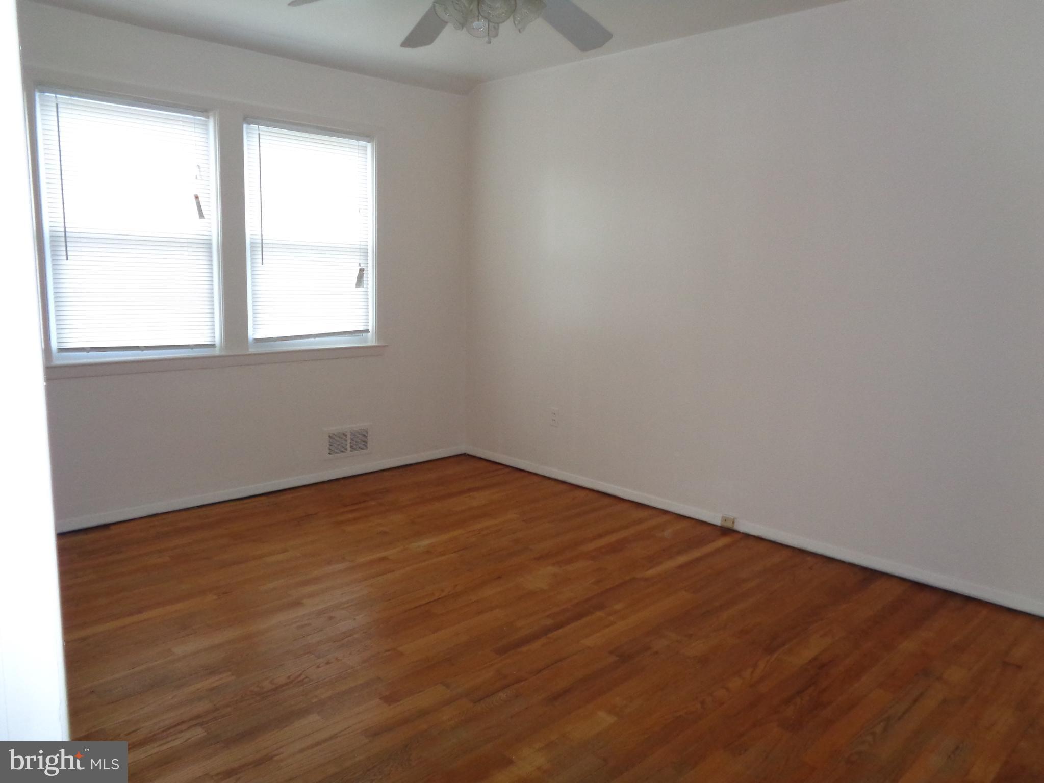 6213 Marlora Road Baltimore, MD 21239 - Photo 15 of 26 an empty room with wooden floor and windows