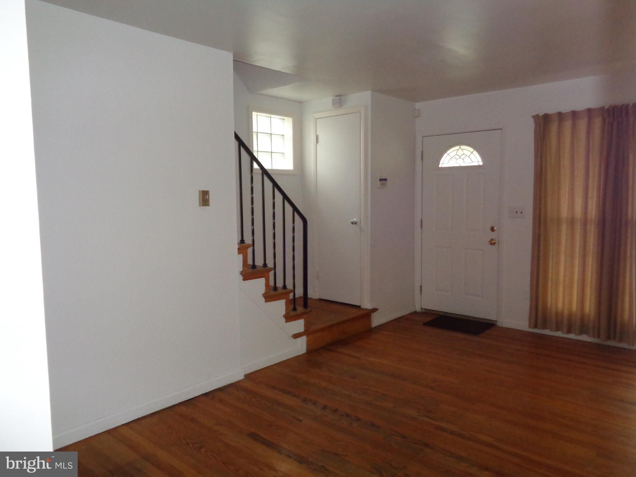 6213 Marlora Road Baltimore, MD 21239 - Photo 3 of 26 an empty room with wooden floor and windows
