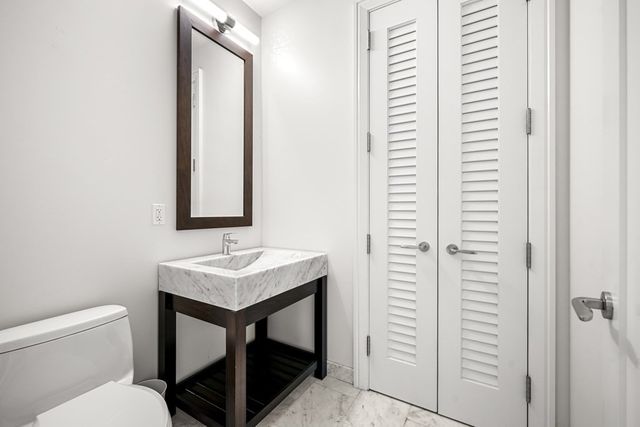 a bathroom with a toilet sink and mirror