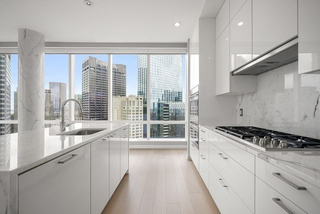 a kitchen with stainless steel appliances kitchen island a stove a sink and cabinets