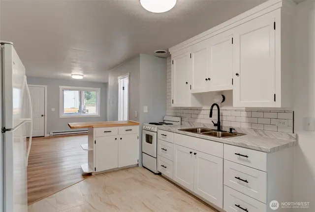 a kitchen with white cabinets and sink