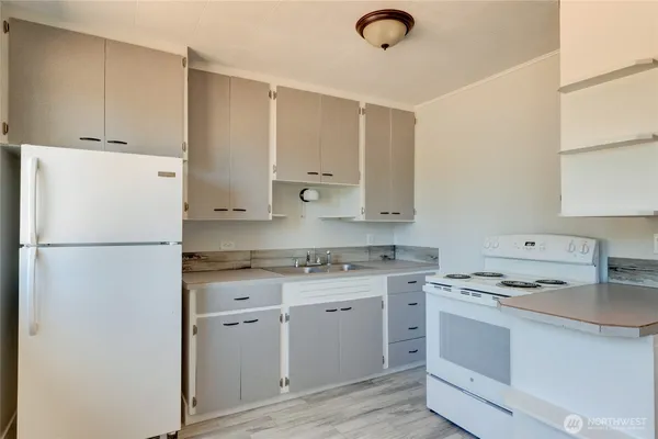 a kitchen with cabinets appliances a sink and a window