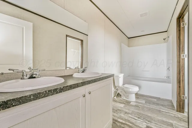 a bathroom with a granite countertop sink toilet a mirror and shower