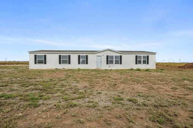 a view of a livingroom with kitchen appliances and a ceiling fan