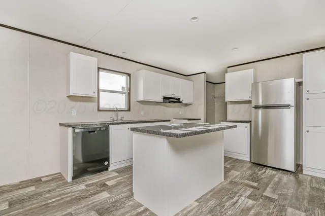 a kitchen with granite countertop a sink appliances cabinets and a counter top space