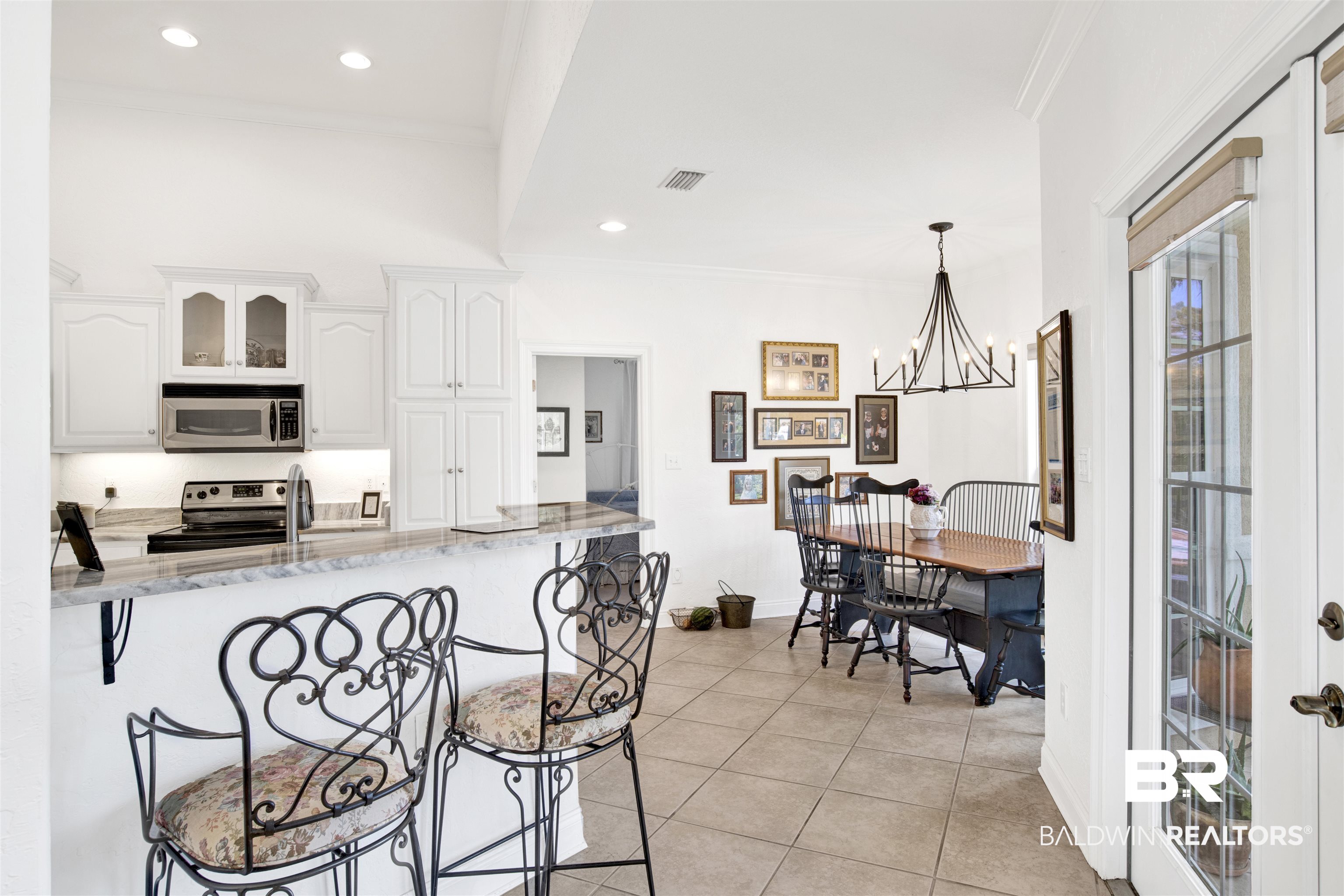 31295 River Road Orange Beach, AL 36561 - Photo 11 of 58 Kitchen with white cabinets, appliances with stainless steel finishes, light stone counters, and pendant lighting