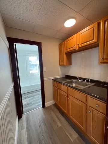 a kitchen with stainless steel appliances granite countertop a sink and wooden floors