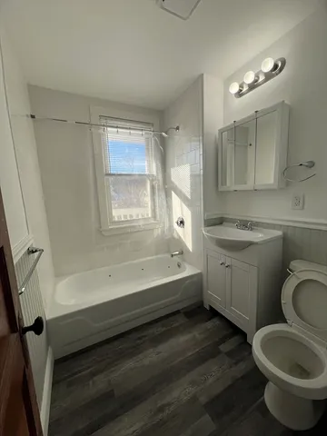a bathroom with a granite countertop toilet a sink and bathtub