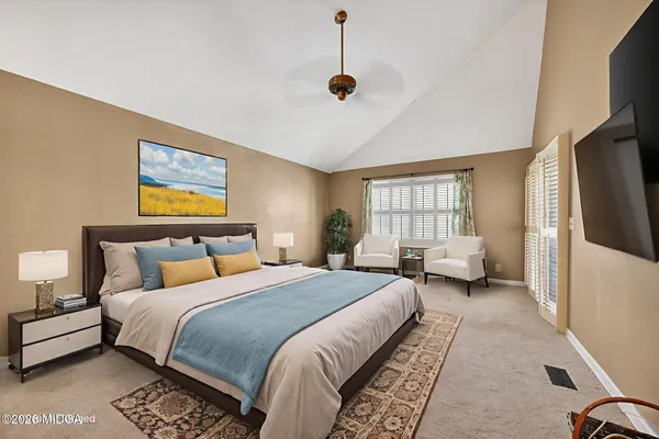 a spacious bedroom with a bed a couch and a window