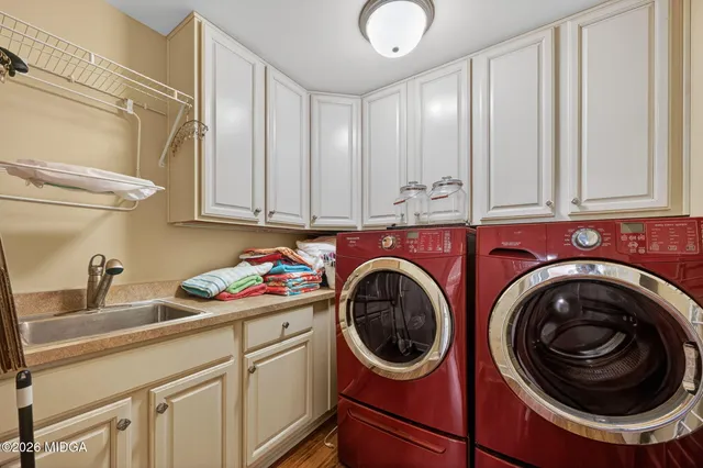 a utility room with sink dryer and washer