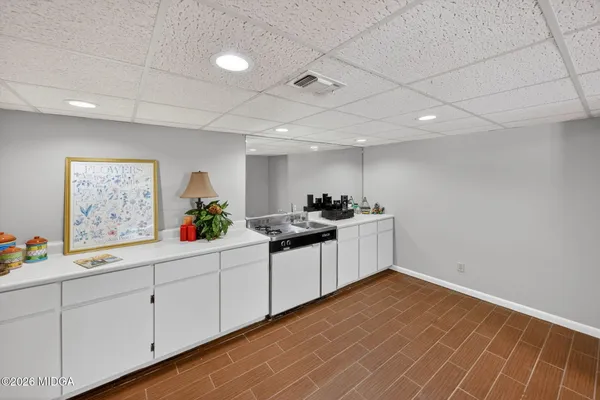 a kitchen with white cabinets and sink