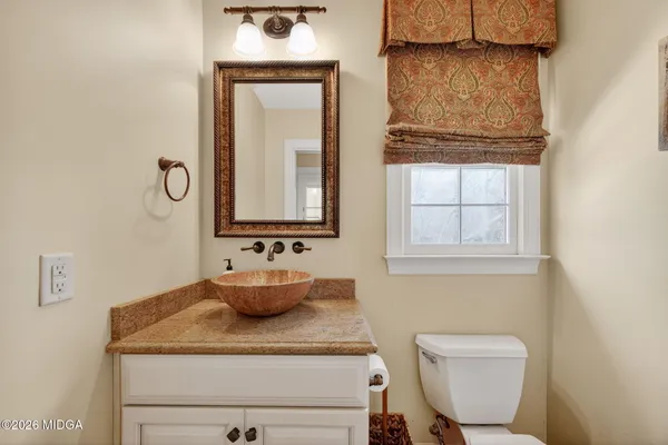 a bathroom with a toilet sink and mirror