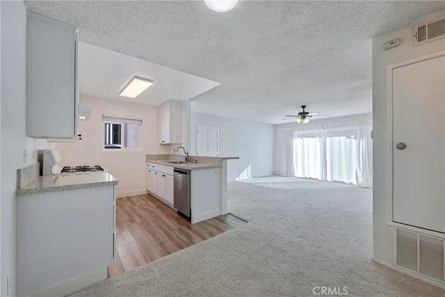 a kitchen with granite countertop a sink cabinets and wooden floor