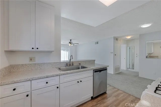 a kitchen with granite countertop white cabinets and a sink