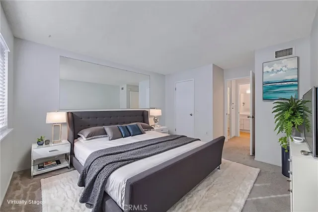 a bedroom with bed and a potted plant