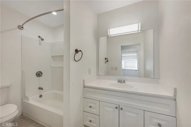 a bathroom with a bathtub shower sink vanity and toilet