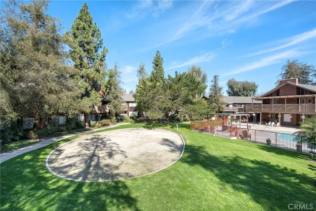 a view of a patio with table and chairs potted plants and large tree