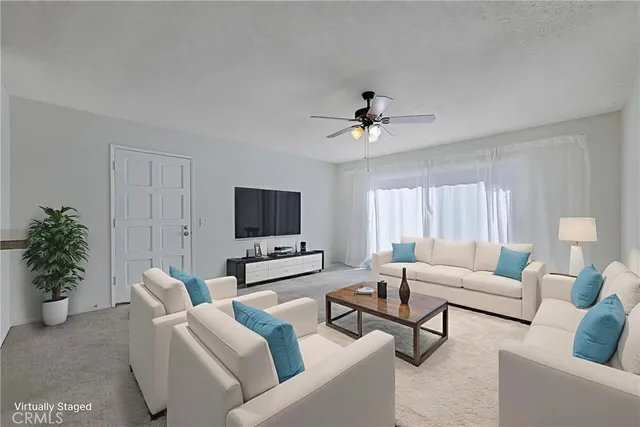 a living room with furniture a potted plant and a flat screen tv
