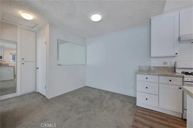 a room with white cabinets and wooden floors