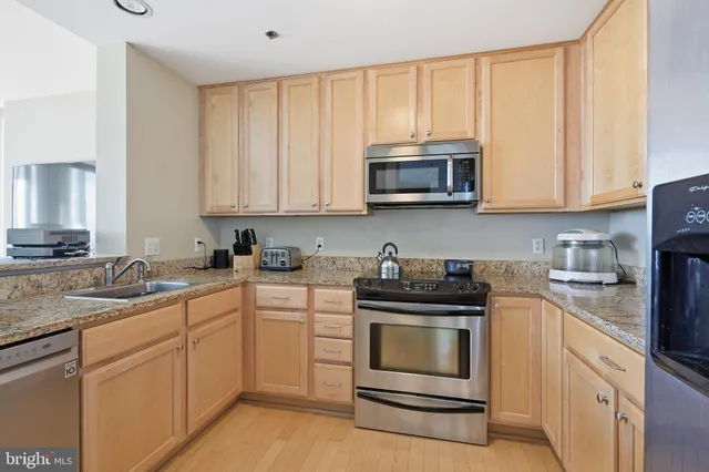 a kitchen with granite countertop white cabinets and stainless steel appliances