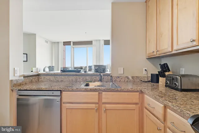 a kitchen with granite countertop a sink and cabinets