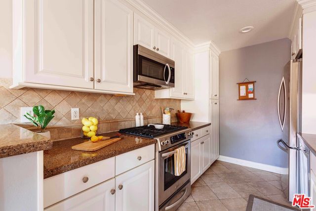 a kitchen with stainless steel appliances granite countertop a sink a stove and a granite counter tops