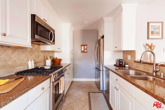 a kitchen with granite countertop a sink and a stove top oven