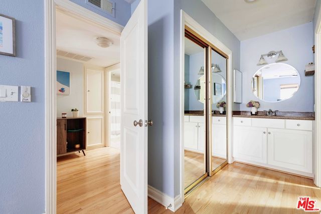 a view of a hallway with bathroom and wooden floor