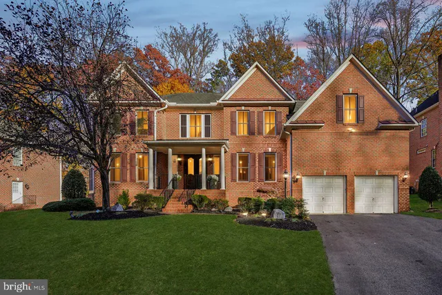 a front view of a house with a yard and trees