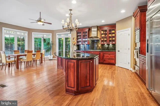 a kitchen with stainless steel appliances granite countertop a refrigerator and a wooden cabinets