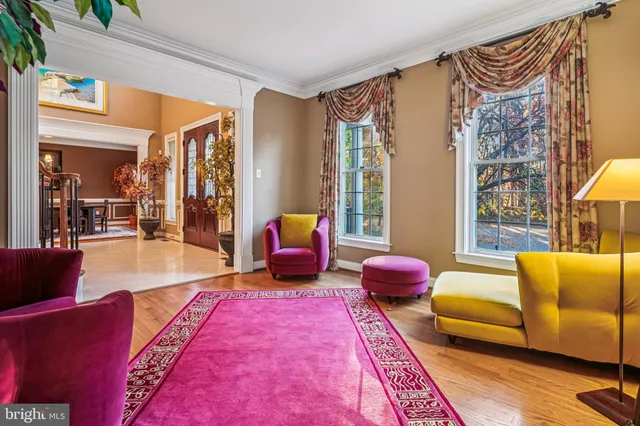 a dining room with wooden floor a chandelier a wooden table and chairs