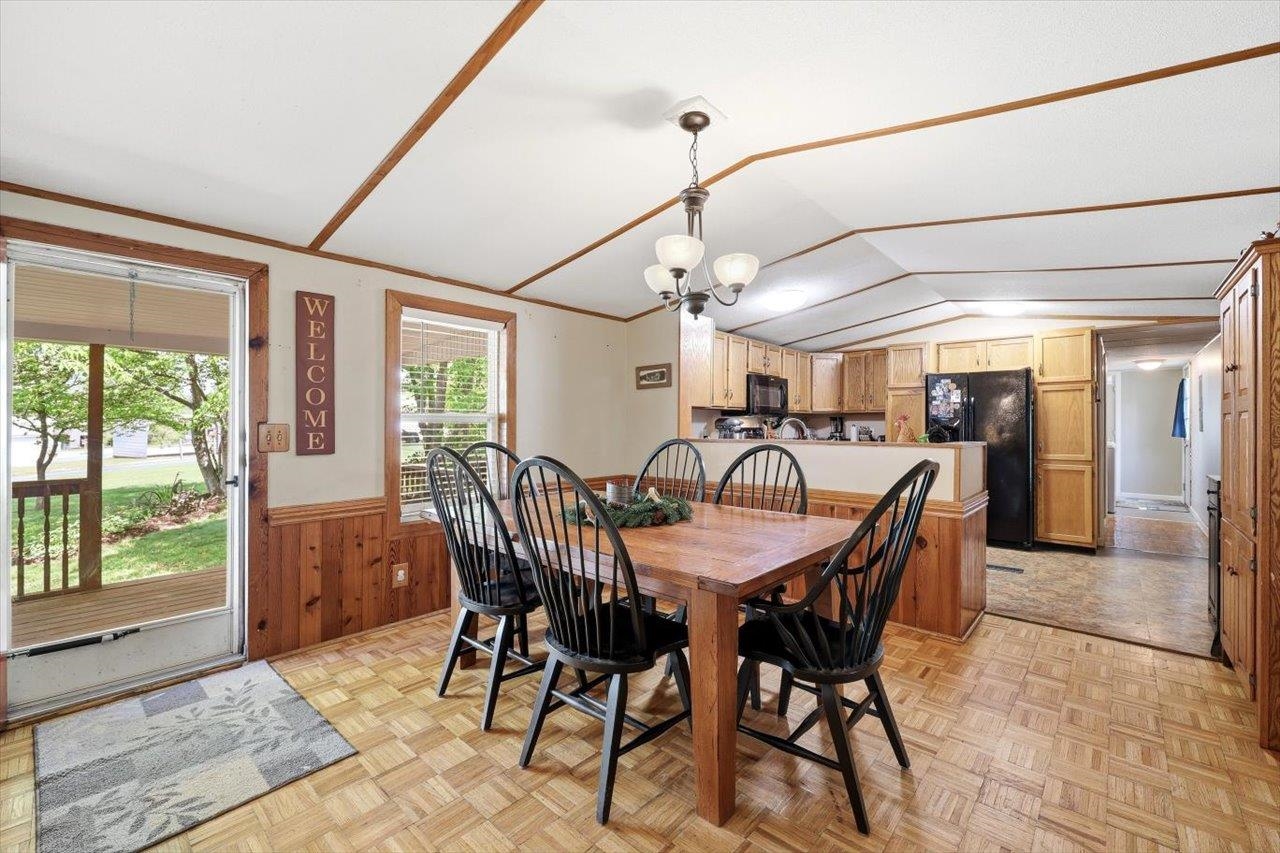 406 Trayfoot Road Grottoes, VA 24441 - Photo 6 of 30 a view of a dining room and livingroom with furniture wooden floor a rug a flat screen tv a potted plant and a chandelier