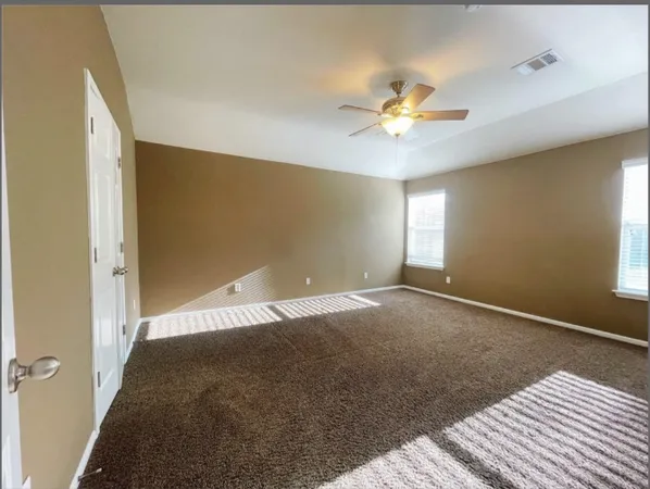 a view of a livingroom with a ceiling fan and window