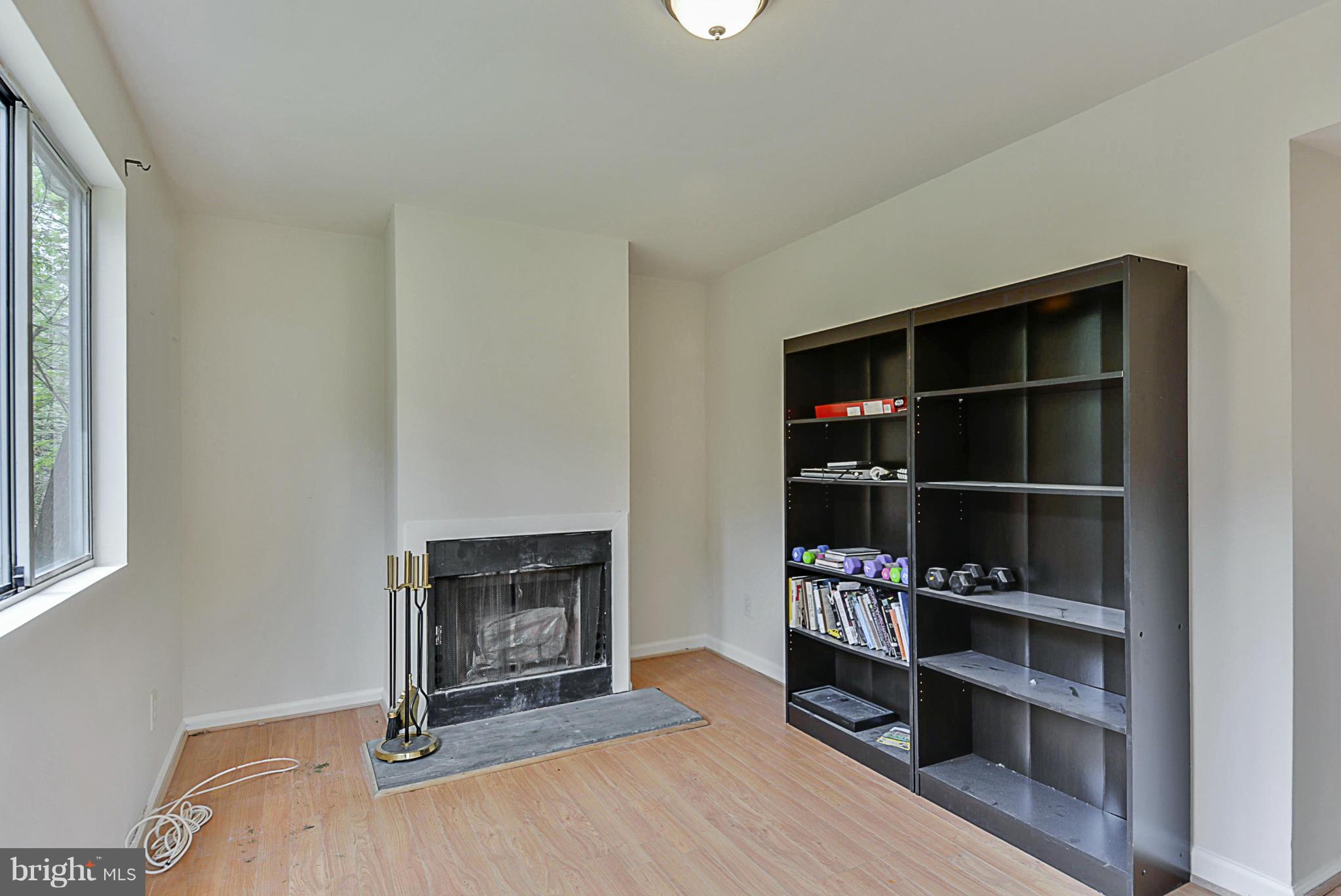 2800 Denley Place Silver Spring, MD 20906 - Photo 8 of 26 a living room with a fireplace and a walk in closet with wooden floor