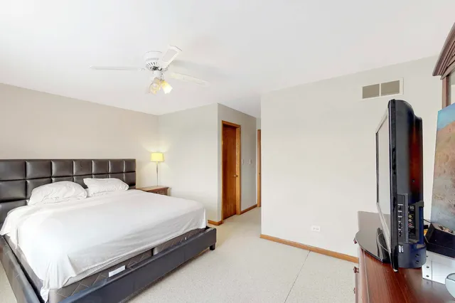 a bedroom with a bed and a flat tv screen on a dresser