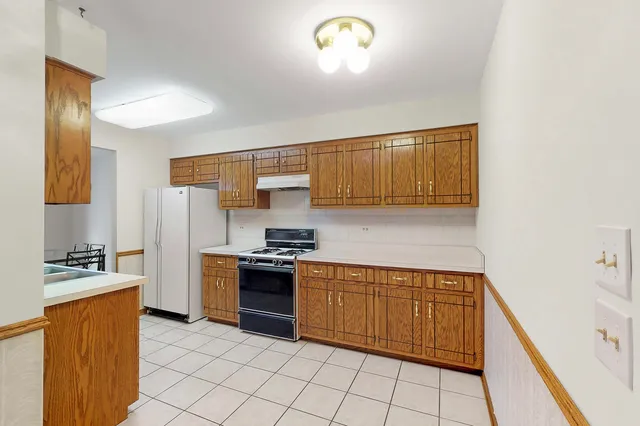 a kitchen with stainless steel appliances granite countertop a stove a sink and a refrigerator