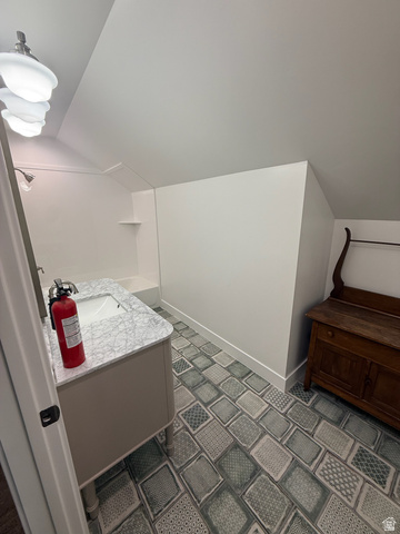 3550 North River Ln Road East Panguitch, UT 84759 - Photo 21 of 25 Bathroom featuring a single vanity with stone-finish countertop and undermount sink, patterned floor tile, and a built-in shower/tub combination