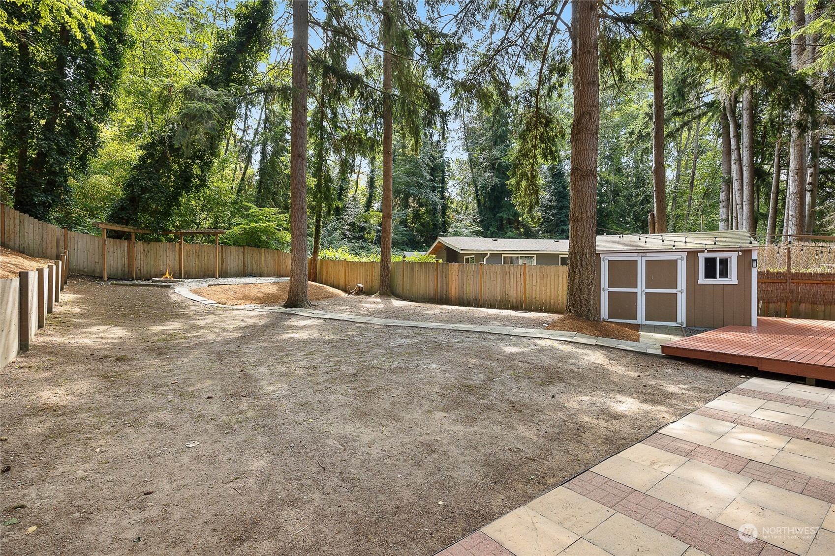 9512 Edmonds Way Edmonds, WA 98020 - Photo 22 of 24 a view of a backyard with large trees and wooden fence
