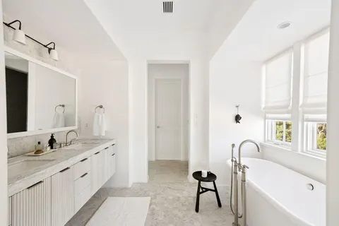 a bathroom with a double vanity sink and a mirror