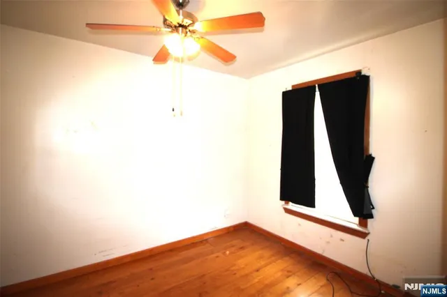 a view of a yard with plants and wooden fence