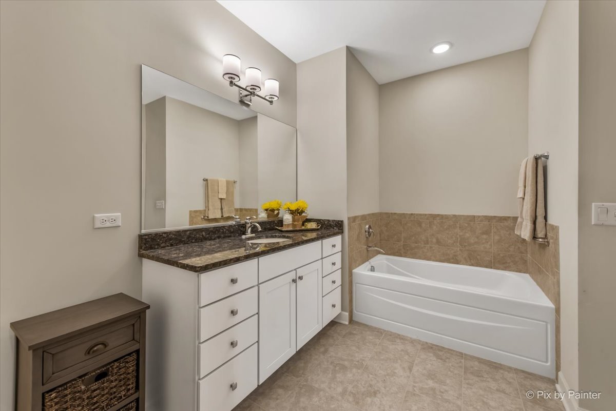2122 Shermer Road Glenview, IL 60026 - Photo 17 of 37 a bathroom with a granite countertop sink a toilet a mirror and bathtub