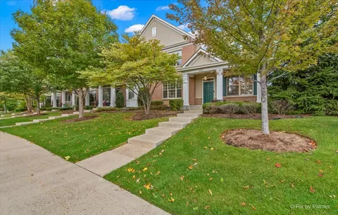 a front view of a house with a yard and trees
