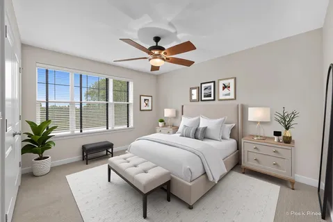 a bedroom with a bed a couch and potted plant