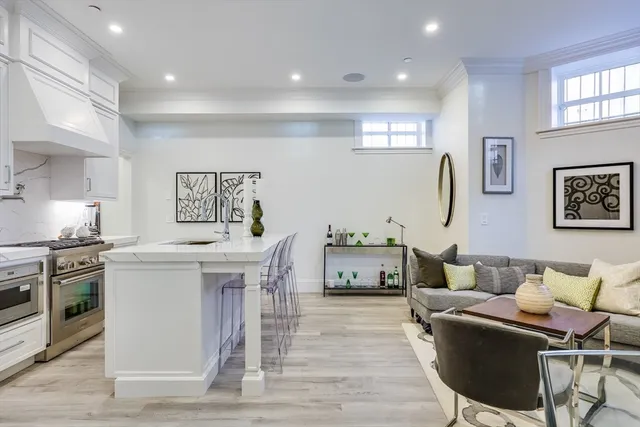 a living room with furniture a flat screen tv and kitchen view