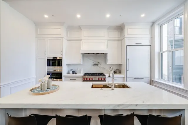 a kitchen with kitchen island stainless steel appliances a sink and a stove