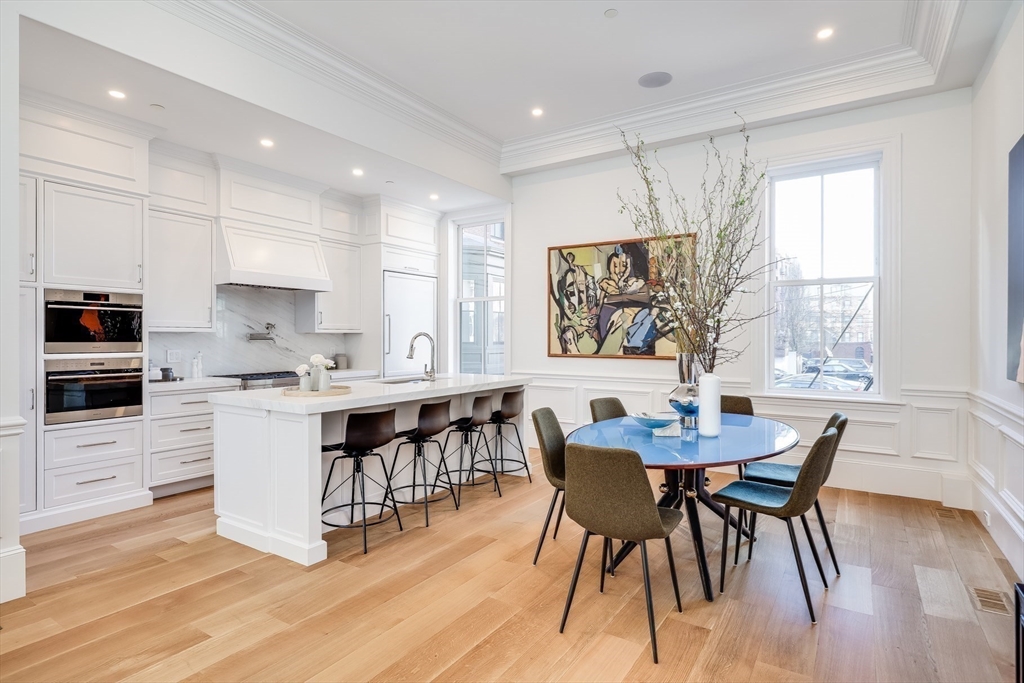 1 Fairfield Street Boston, MA 02116 - Photo 3 of 28 a kitchen with a dining table chairs and white cabinets
