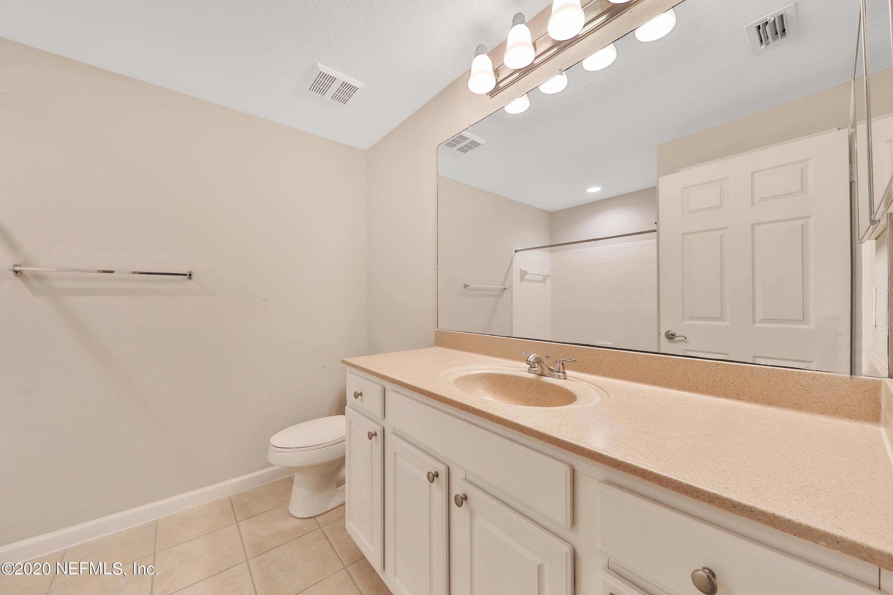 10075 Gate Parkway, Unit 1009 Jacksonville, FL 32246 - Photo 27 of 51 a bathroom with a granite countertop sink a toilet and a mirror