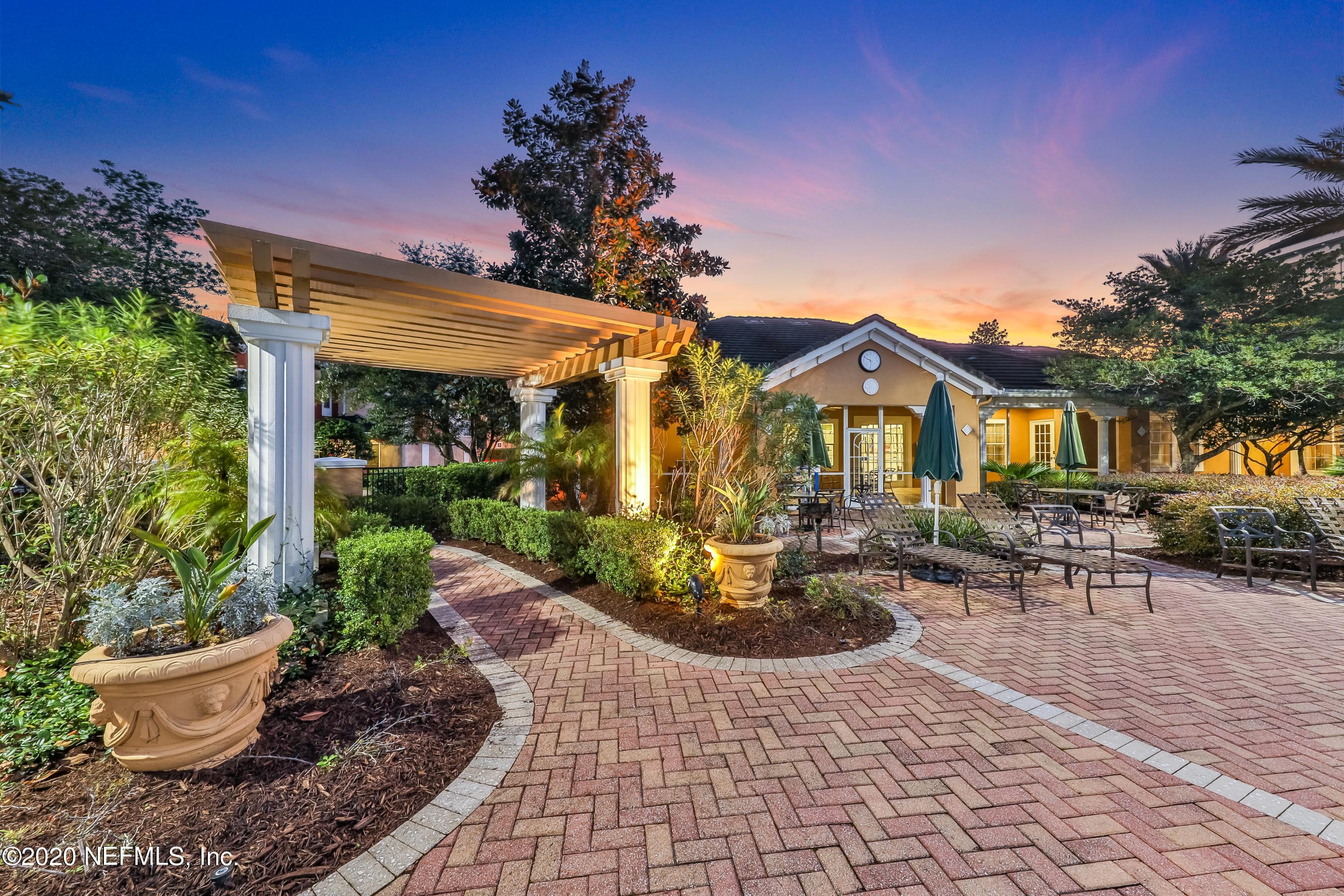 10075 Gate Parkway, Unit 1009 Jacksonville, FL 32246 - Photo 51 of 51 a view of a patio with table and chairs potted plants and a large tree