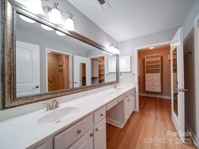 a spacious bathroom with a double vanity sink and a large mirror